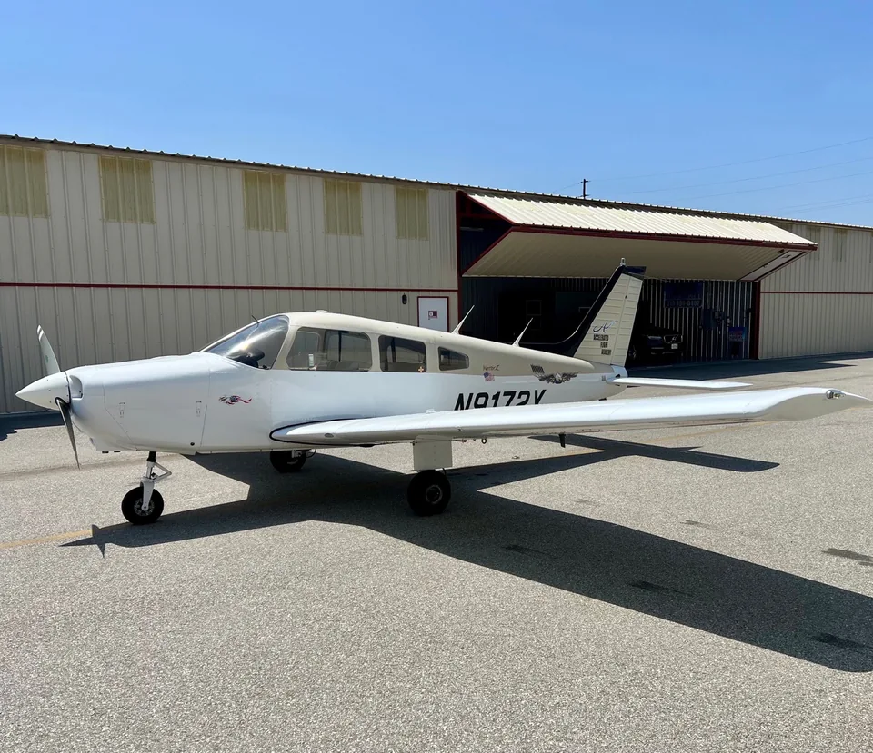 Front-left view of Accelerated Flight Academy's Piper Warrior II N9172Y outside the hangar at Van Nuys Airport