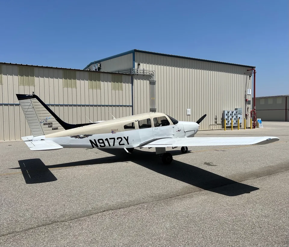 Rear-right view of Piper Warrior II N9172Y, with the academy logo on the tail and the full right wing visible